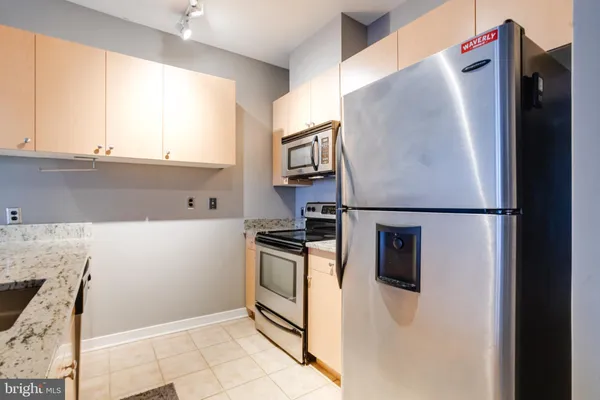 a kitchen with stainless steel appliances granite countertop a refrigerator and a stove