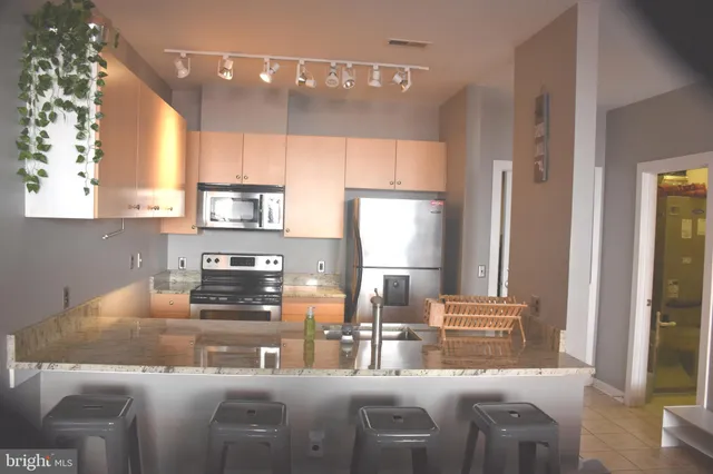 a kitchen with stainless steel appliances granite countertop a sink a stove and a refrigerator