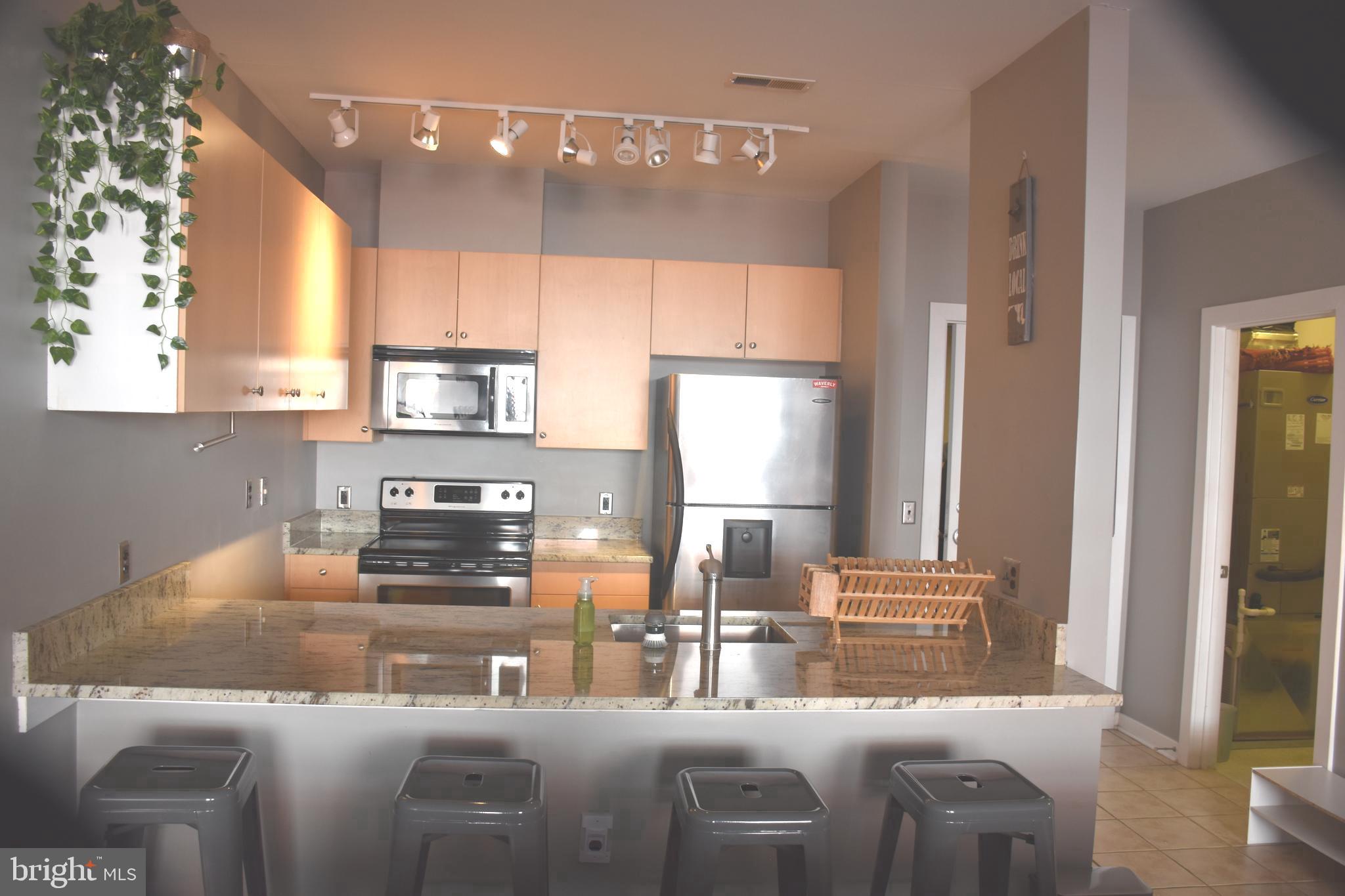 2007 Clipper Park Road, Unit 212 Baltimore, MD 21211 - Photo 10 of 33 a kitchen with stainless steel appliances granite countertop a sink a stove and a refrigerator