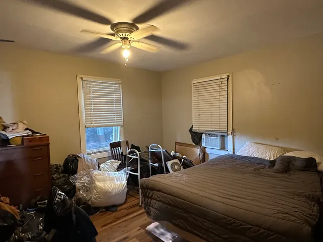 a bedroom with bed a chair and a chandelier