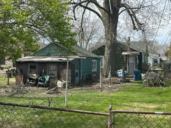 a view of a chair and table in backyard of the house