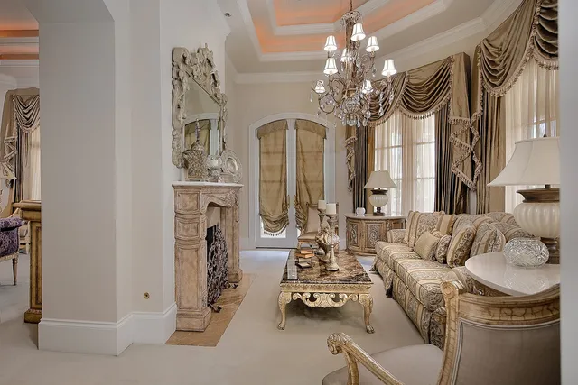 a living room with furniture a fireplace and chandelier
