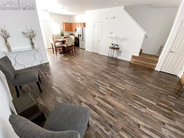 a living room with furniture and a dining table with kitchen view