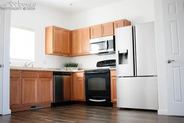 a kitchen with stainless steel appliances granite countertop a refrigerator and a stove top oven