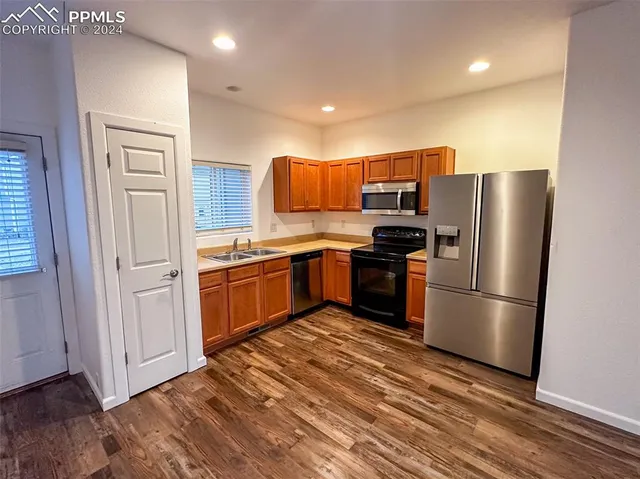 a view of an empty room and chandelier fan