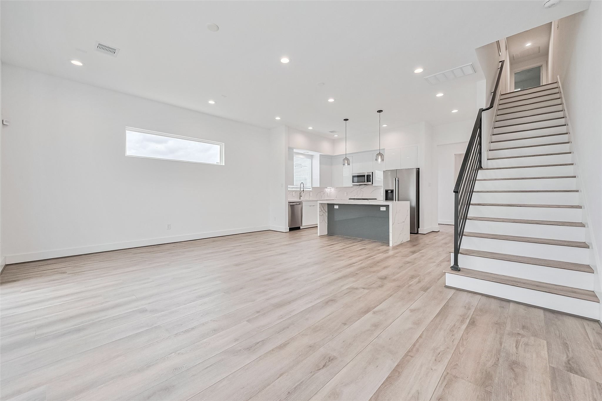 a view of kitchen with wooden floor and electronic appliances