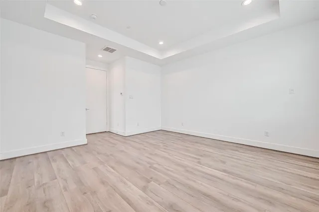 a view of an empty room with wooden floor