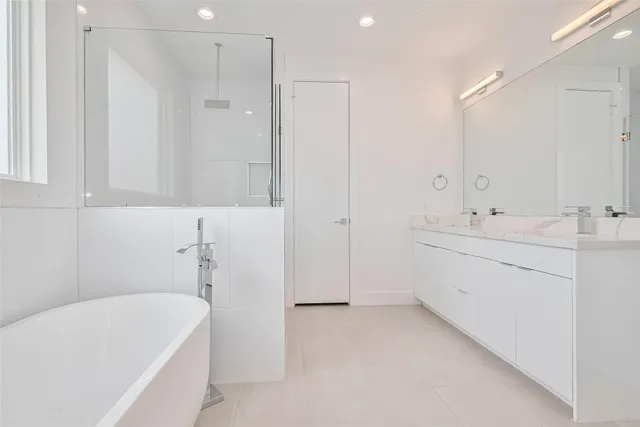 a bathroom with a bathtub a sink a vanity and a shower