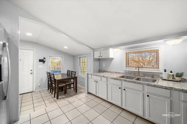 a kitchen with a sink and chairs