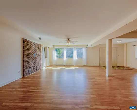 a view of empty room with wooden floor and ceiling fan