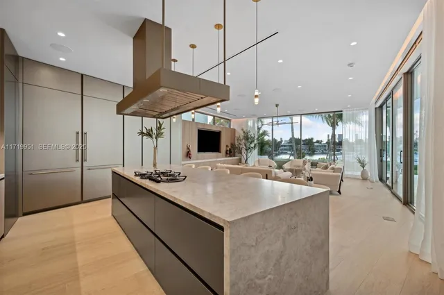 a kitchen with stainless steel appliances kitchen island a table chairs sink and cabinets