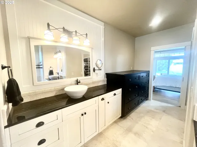 a spacious bathroom with double vanity and mirrors