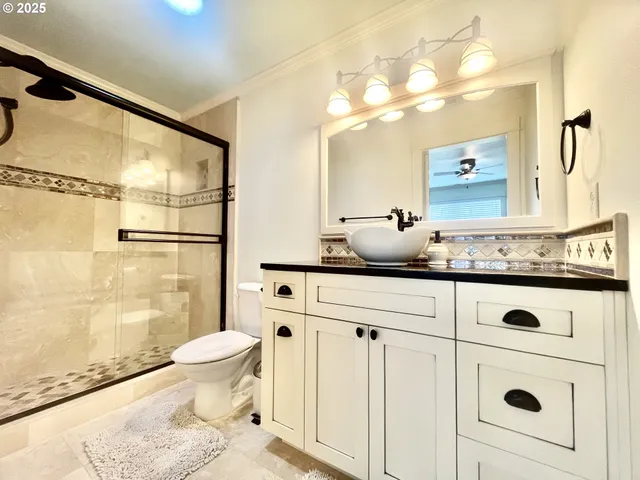 a bathroom with a granite countertop sink mirror vanity and toilet