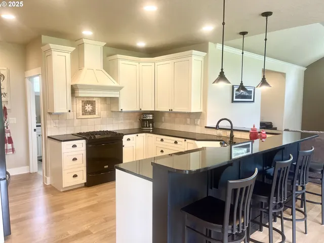 a kitchen with kitchen island granite countertop a sink a counter and chairs