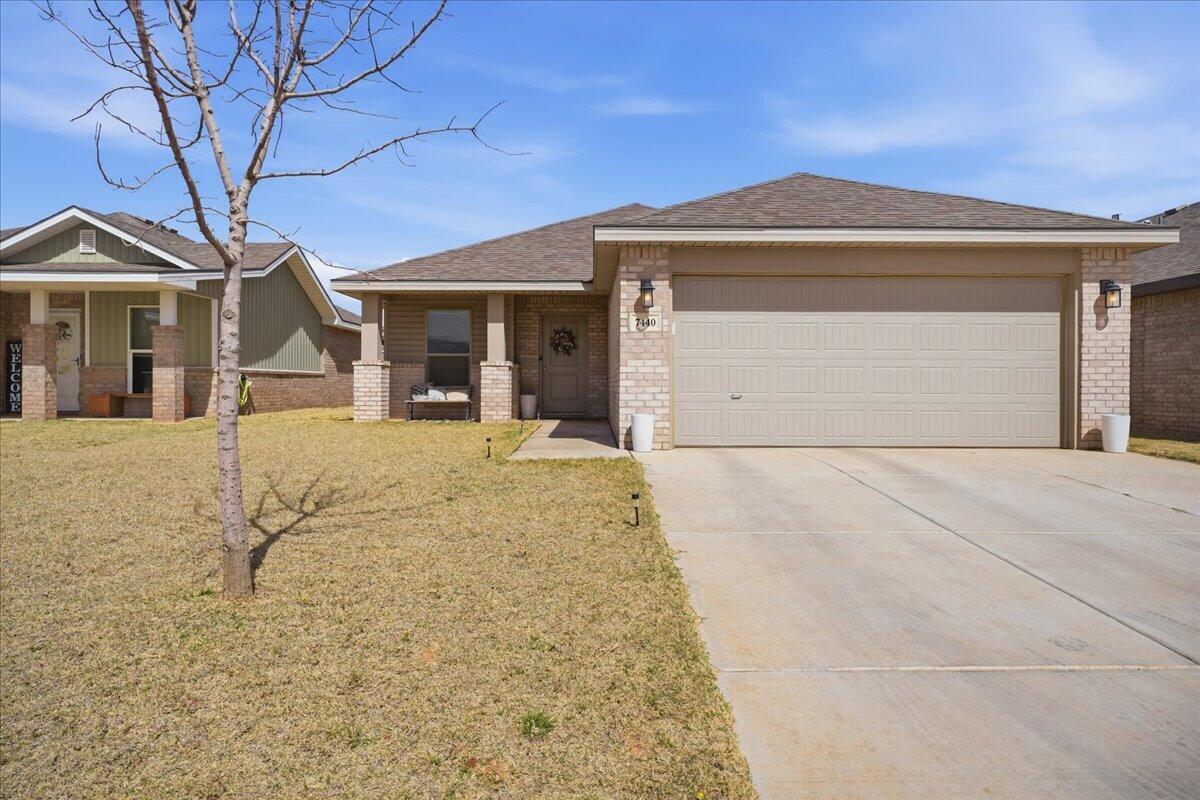 7440 32nd Street Lubbock, TX 79407 - Photo 1 of 29 a front view of a house with a yard and garage