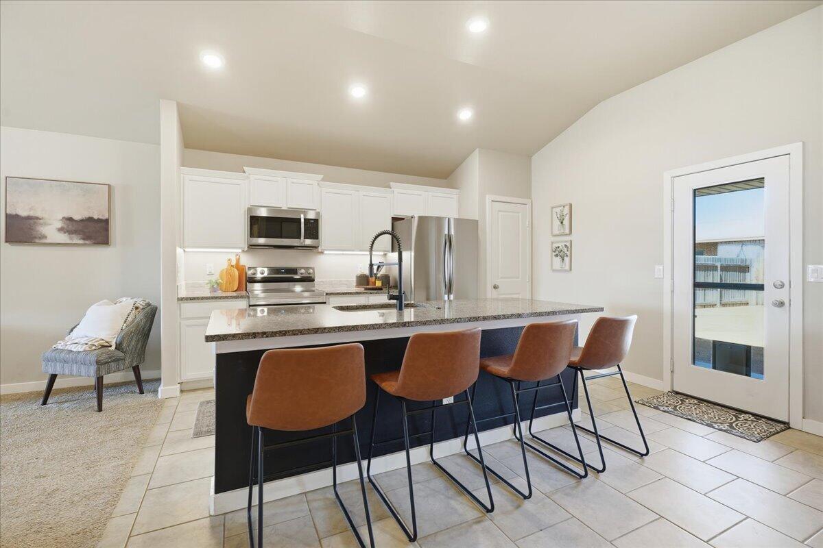 7440 32nd Street Lubbock, TX 79407 - Photo 11 of 29 a dining hall with stainless steel appliances kitchen island granite countertop a dining table chairs and view living room