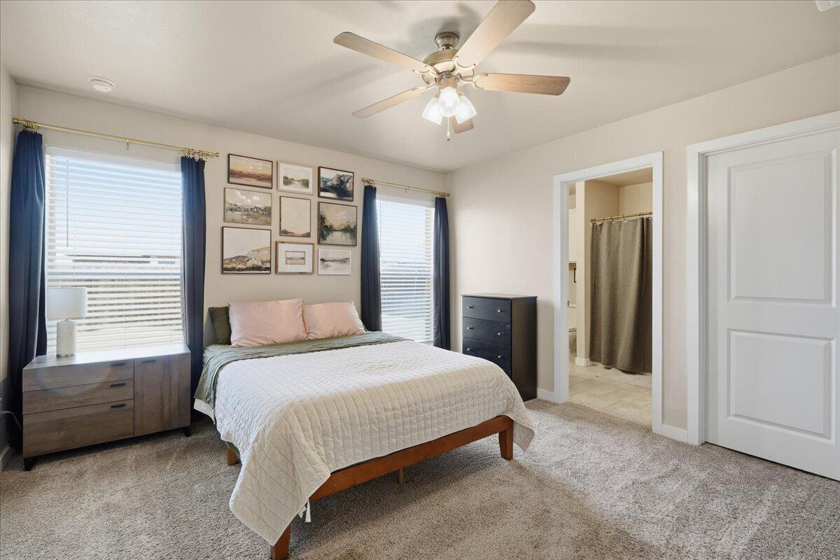 7440 32nd Street Lubbock, TX 79407 - Photo 18 of 29 a bedroom with a bed and a chandelier