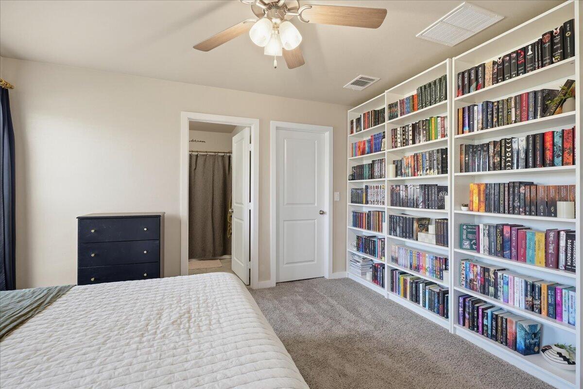 7440 32nd Street Lubbock, TX 79407 - Photo 19 of 29 a bedroom with a bed and a book shelf