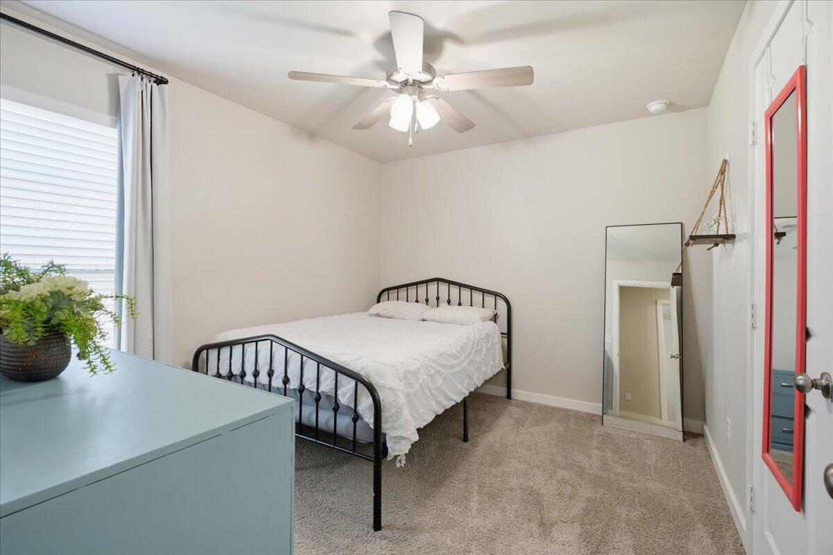 7440 32nd Street Lubbock, TX 79407 - Photo 23 of 29 a bedroom with a bed and a chandelier