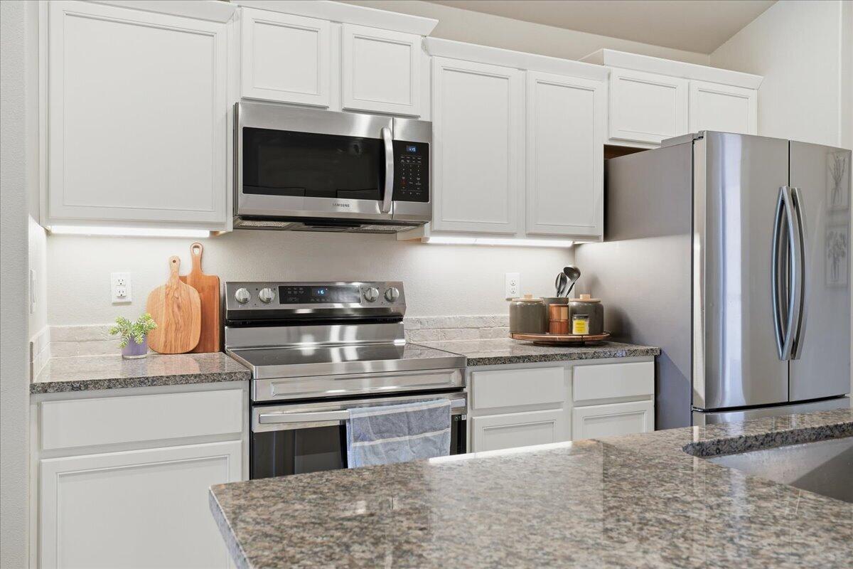 7440 32nd Street Lubbock, TX 79407 - Photo 7 of 29 a kitchen with stainless steel appliances granite countertop a refrigerator stove and microwave