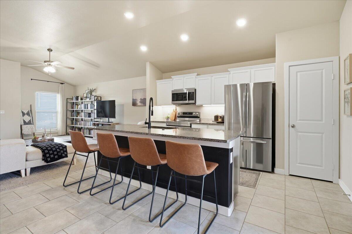 7440 32nd Street Lubbock, TX 79407 - Photo 10 of 29 a kitchen with stainless steel appliances a refrigerator a stove a sink a dining table and chairs
