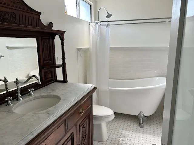 a bathroom with a granite countertop sink a toilet and a bathtub