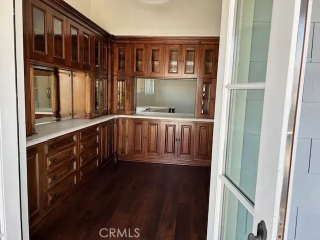 a view of a kitchen with an empty room and wooden floor