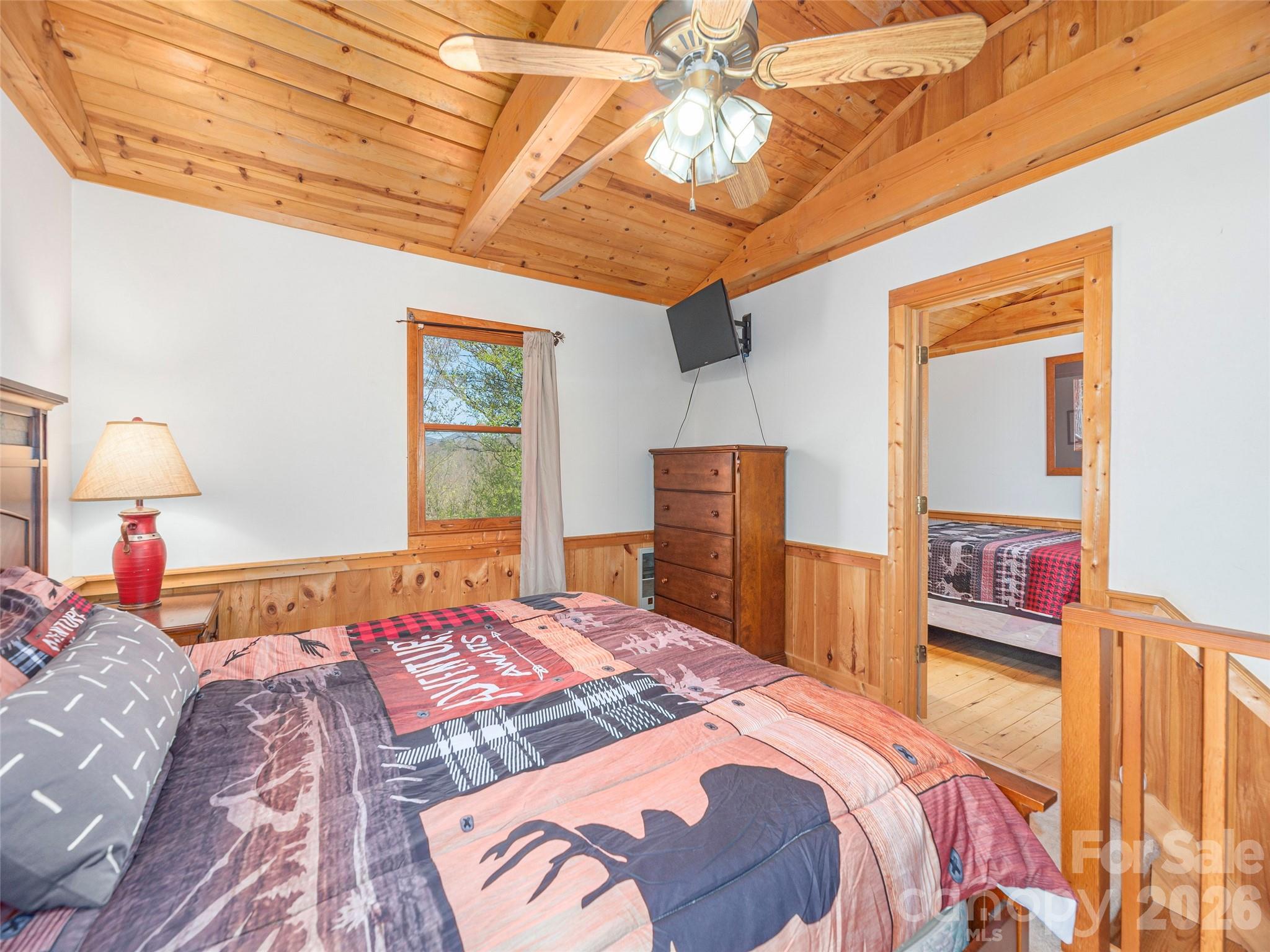 240 Plott Balsam Road Maggie Valley, NC 28751 - Photo 14 of 24 a bedroom with a bed and a chandelier