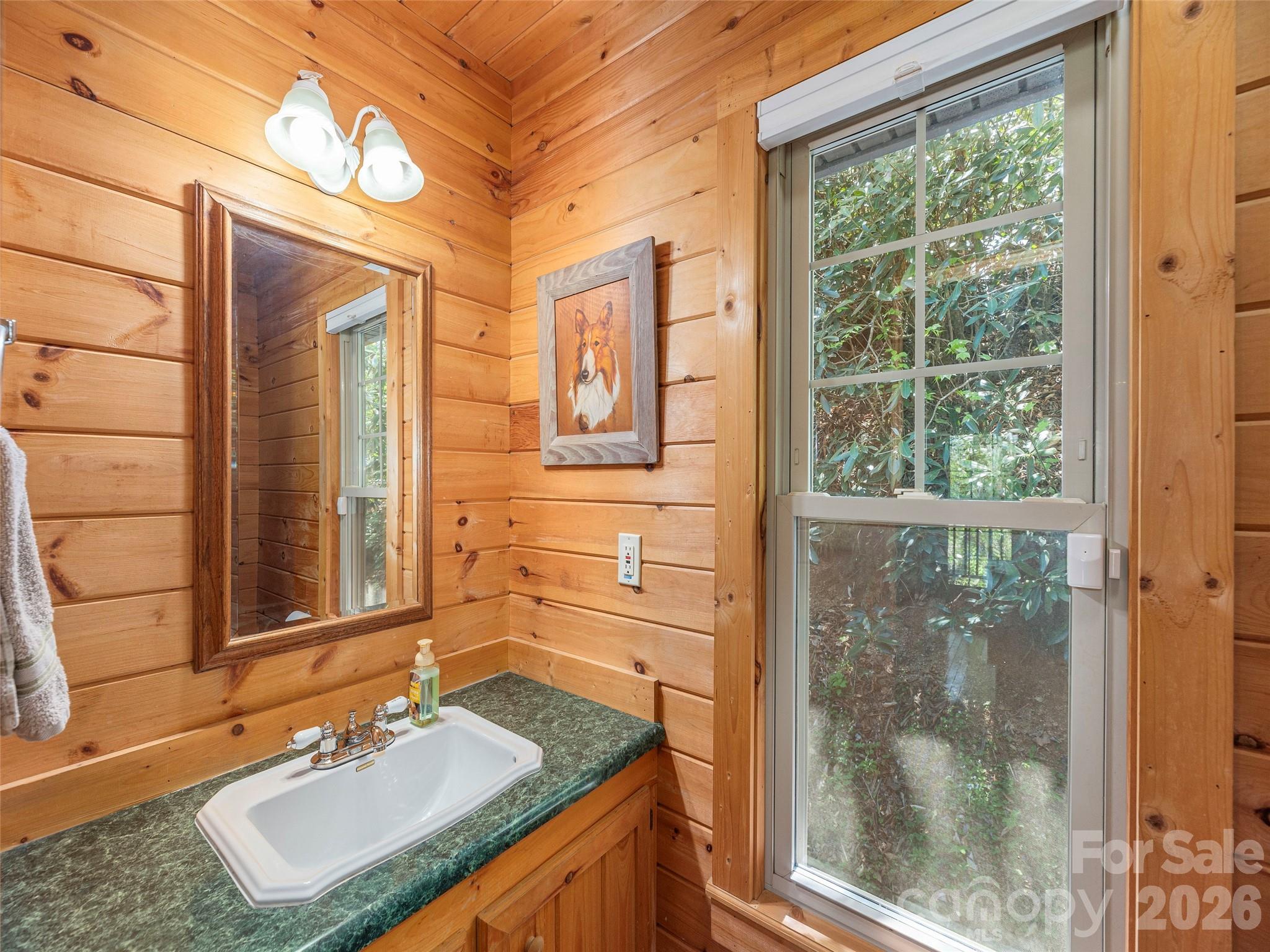 240 Plott Balsam Road Maggie Valley, NC 28751 - Photo 7 of 24 a bathroom with a granite countertop sink a mirror and a shower
