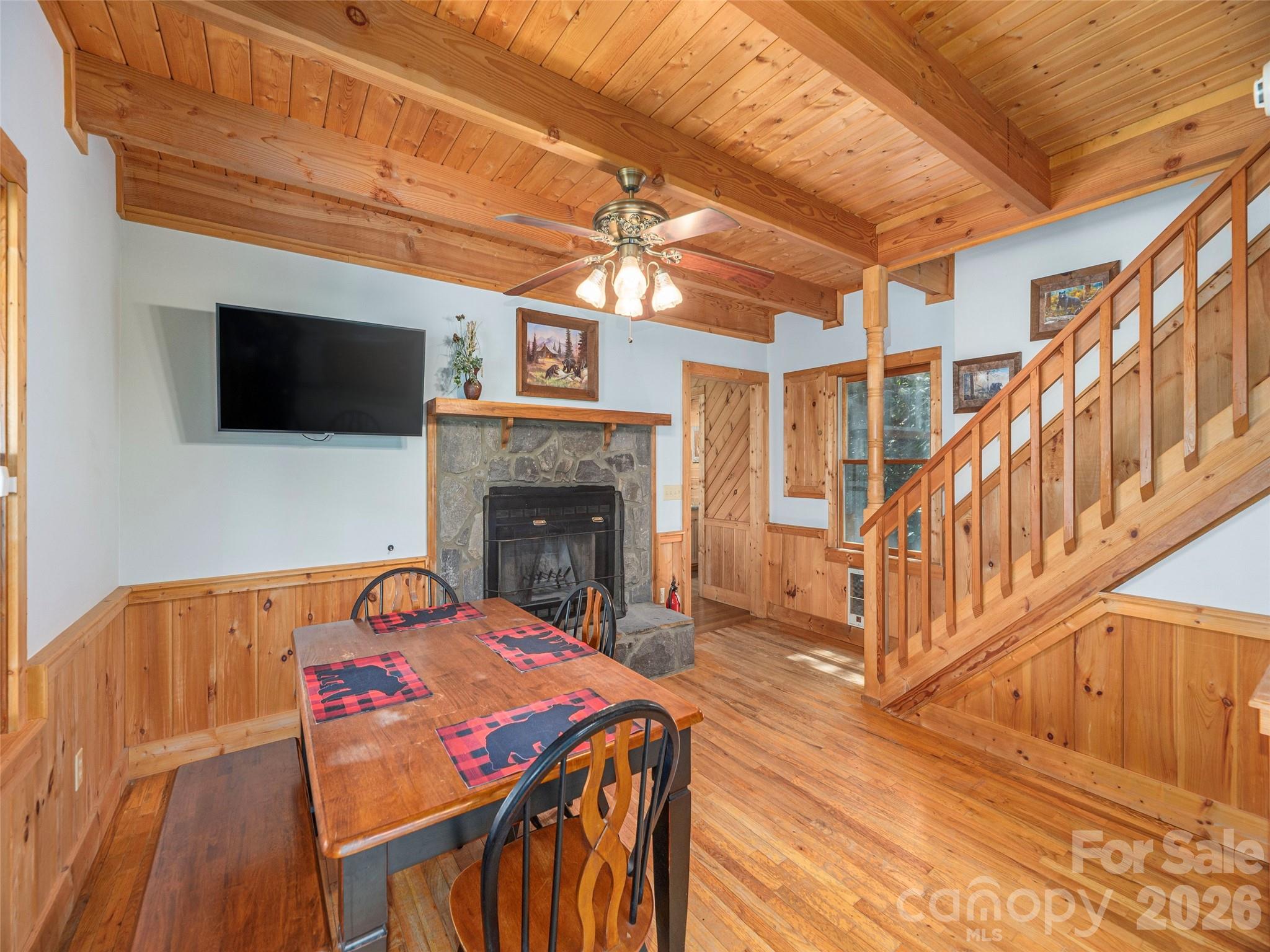 240 Plott Balsam Road Maggie Valley, NC 28751 - Photo 8 of 24 a view of a dining room with furniture a fireplace and wooden floor