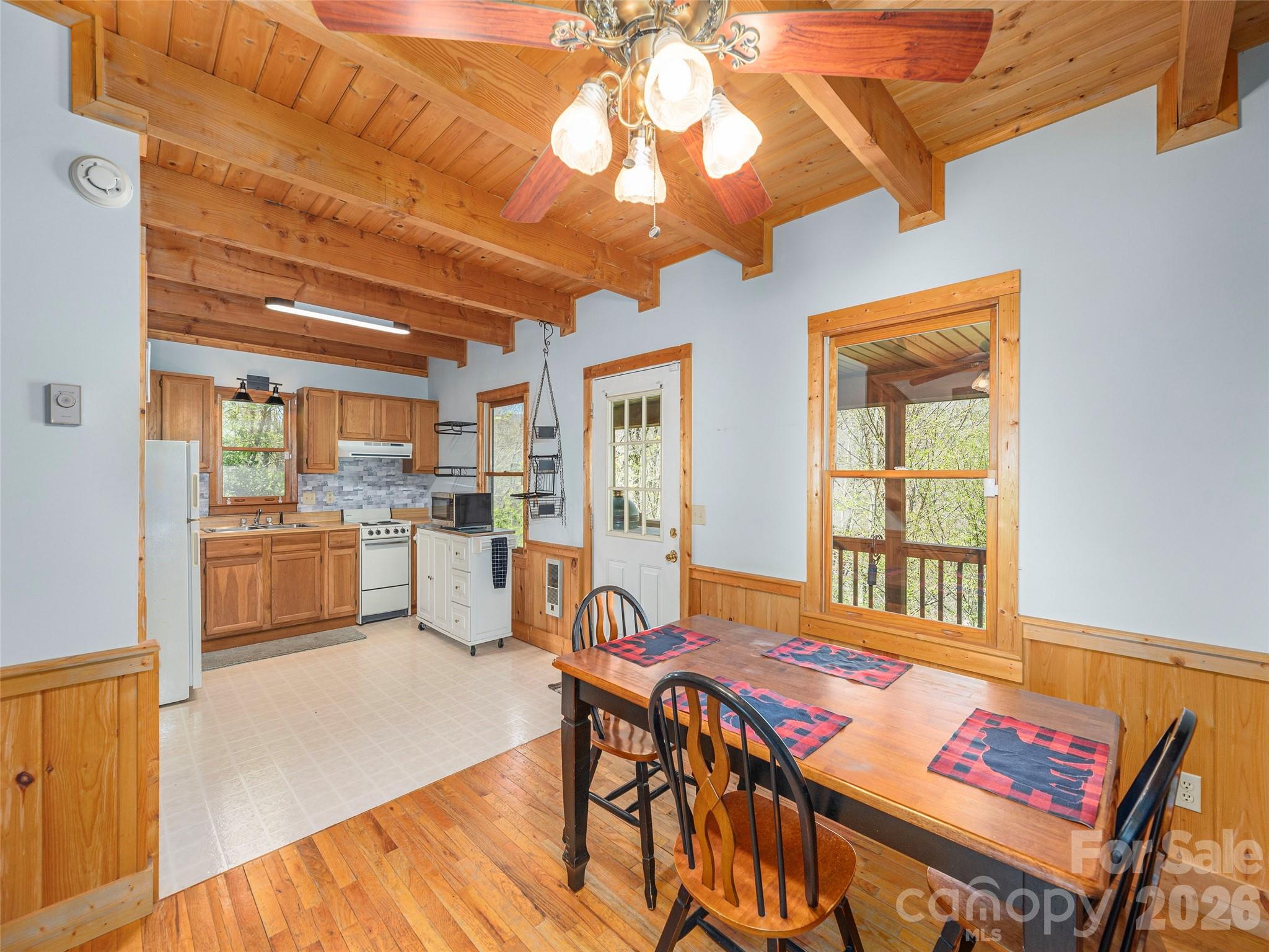 240 Plott Balsam Road Maggie Valley, NC 28751 - Photo 9 of 24 a open kitchen with stainless steel appliances granite countertop a stove a refrigerator a dining table and chairs with wooden floor