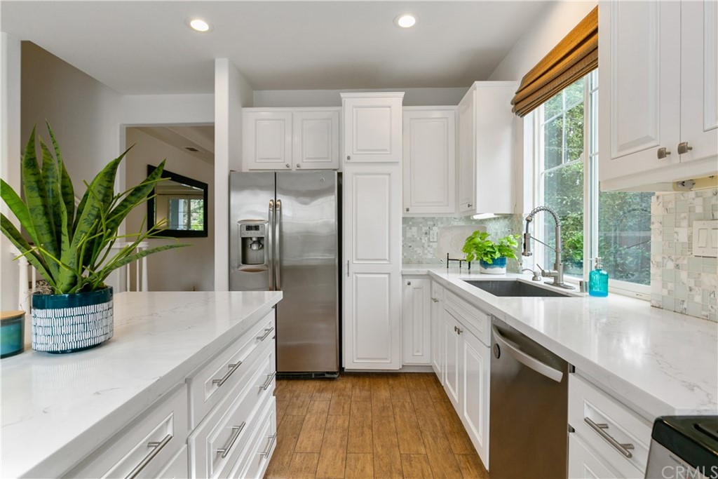 4 Bainbridge Avenue Ladera Ranch, CA 92694 - Photo 7 of 23 a kitchen with a potted plant on the counter and a glass window