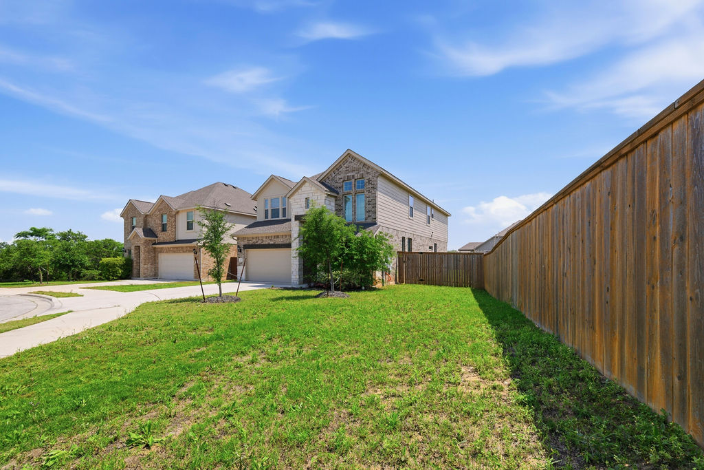 1005 Ridge Runner Drive Georgetown, TX 78628 - Photo 2 of 32 Expansive grassy yard with wood perimeter fencing, offering privacy