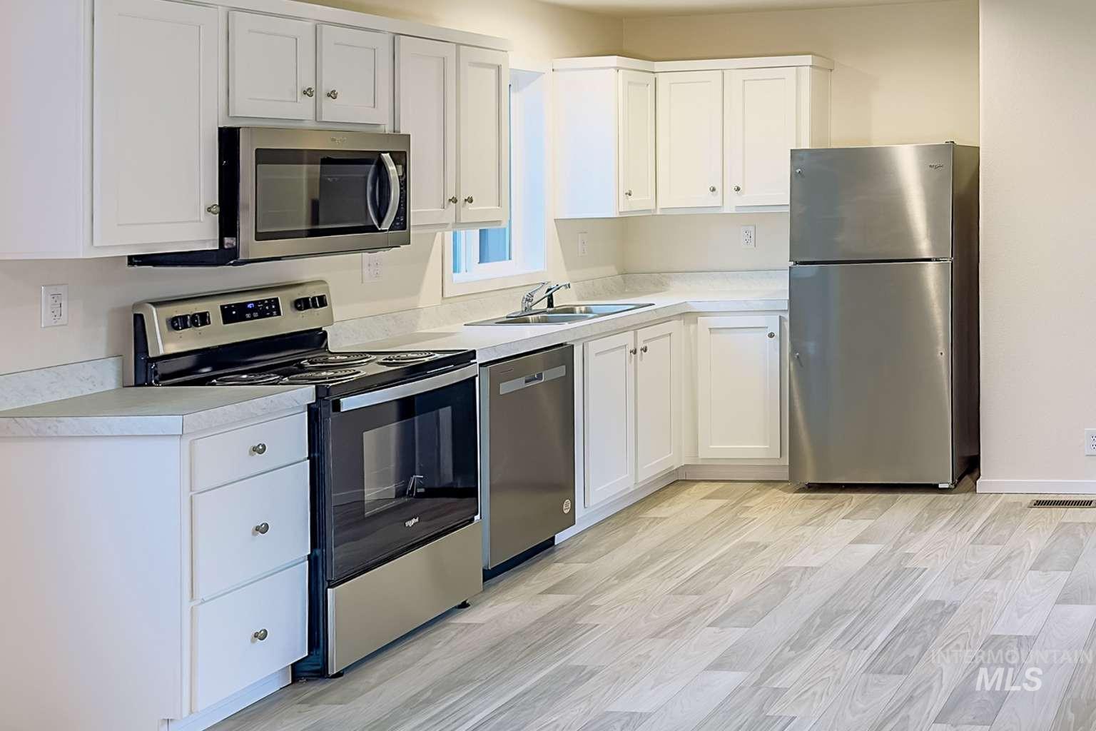 10 Kamloop Lane Orofino, ID 83544 - Photo 3 of 17 Kitchen featuring white cabinetry, light-toned countertops, and stainless steel appliances