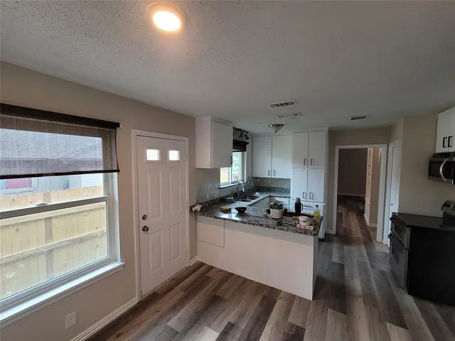 a kitchen view of a stove and a wooden floor