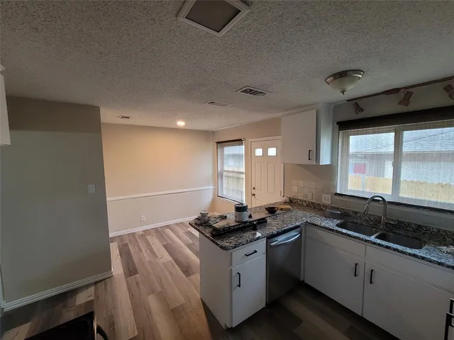 a kitchen with granite countertop a sink a stove and cabinets