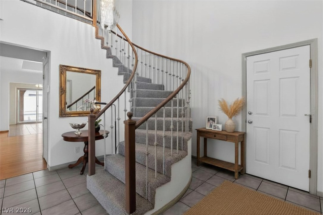 3698 Laughlin Boulevard Laughlin, NV 89029 - Photo 11 of 49 A grand curved staircase with rich wood banister and gray carpeted treads defines this welcoming entry.