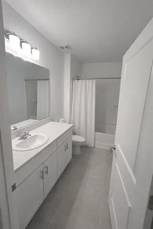 a bathroom with a double vanity sink and mirror with shower