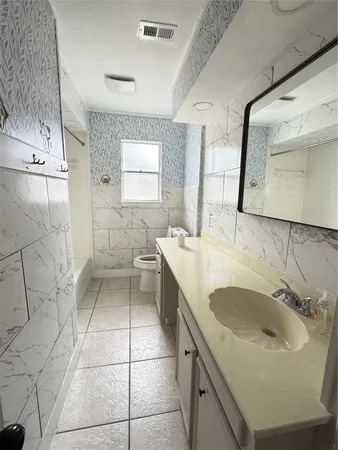 a bathroom with a sink a toilet and mirror