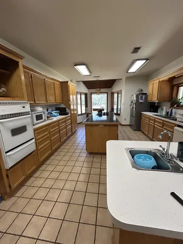 a kitchen with a sink a stove top oven a counter space and cabinets