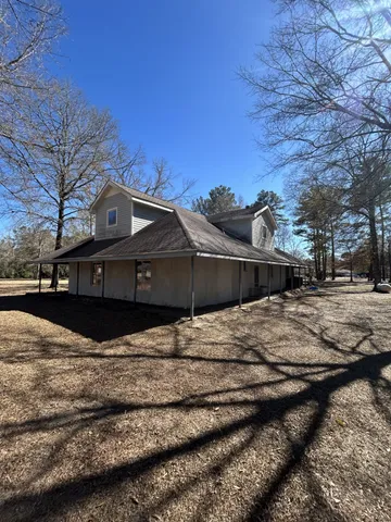 a front view of a house with a yard covered with snow in front of house