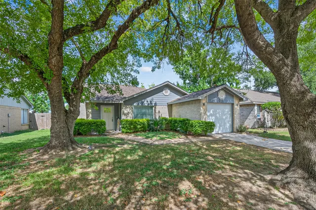 a front view of a house with yard and tree