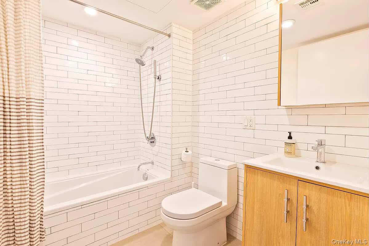 116 Covert Street, Unit 2A Brooklyn, NY 11207 - Photo 3 of 6 Full bath with tile walls, vanity, tiled shower / bath combo, recessed lighting, and tasteful backsplash