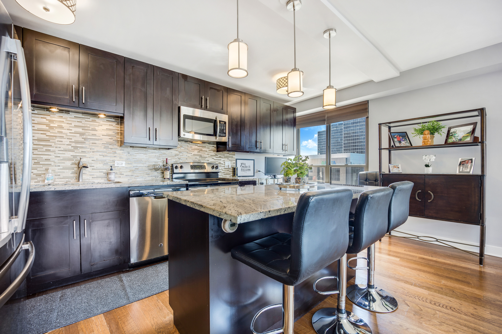 2930 North Sheridan Road, Unit 1401 Chicago, IL 60657 - Photo 9 of 23 a kitchen with stainless steel appliances granite countertop a stove a refrigerator a sink a dining table and chairs