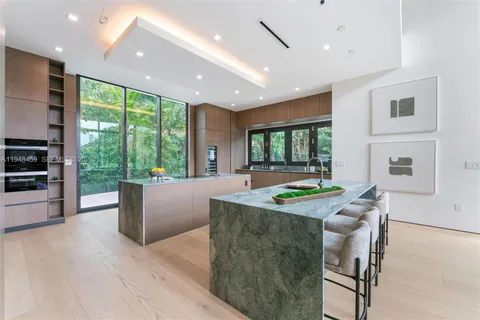 a kitchen with kitchen island a large window in it