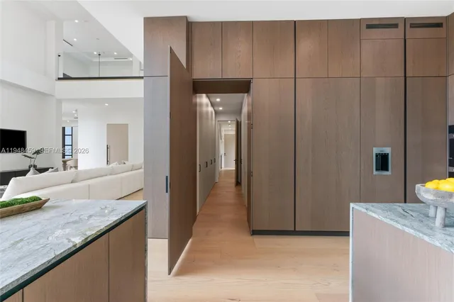 a living room with couches a flat screen tv and a floor to ceiling window