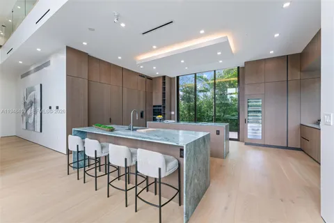 a kitchen with kitchen island a large window in it