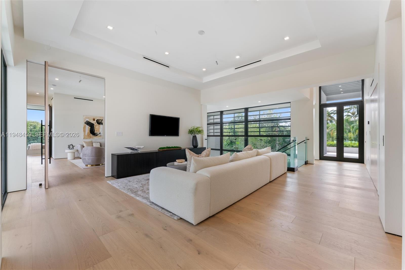 5845 Southwest 130th Terrace Pinecrest, FL 33156 - Photo 27 of 44 a living room with furniture large window and a flat screen tv