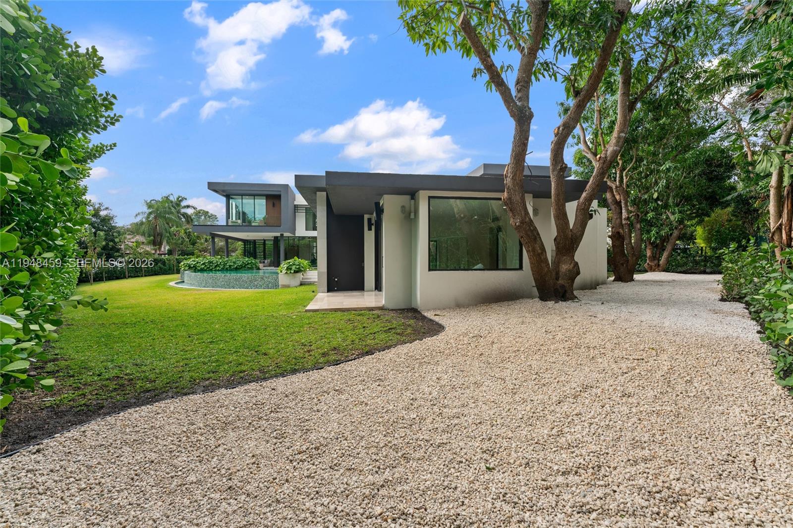 5845 Southwest 130th Terrace Pinecrest, FL 33156 - Photo 52 of 55 a view of a house with backyard and a tree