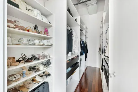 a view of walk in closet with clothes and shoes